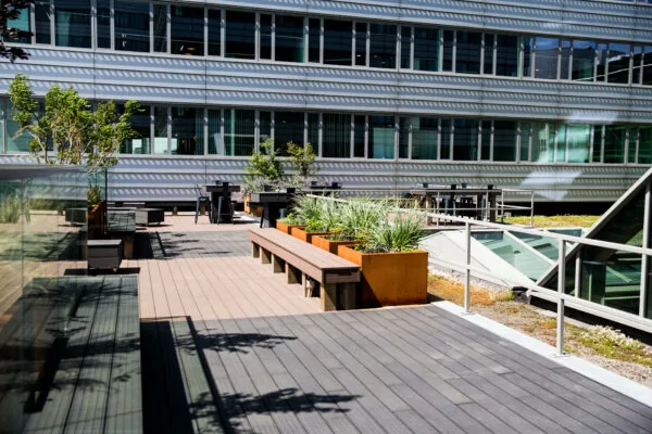 Zonnig dakterras bij HNK Den Haag met zitplekken, plantenbakken en moderne kantooromgeving.