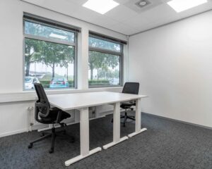 Modern ingericht kantoor met twee bureaus en grote ramen aan de Hurksestraat 43 in Eindhoven.