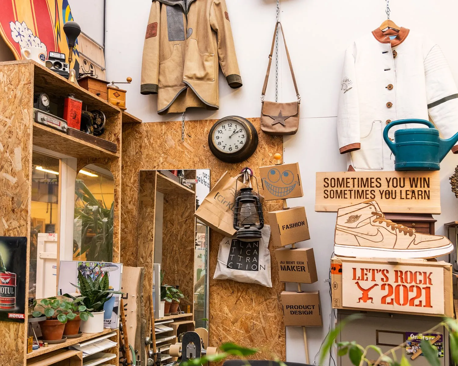 Creatieve en kleurrijke kantoorruimte in Almere met houten wanden, retroobjecten, kledingstukken en motiverende borden.