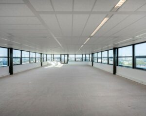 Leegstaande, lichte kantoorruimte te huur aan de Bloemlaan 2 in Hoofddorp met ramen rondom en uitzicht op de stad.