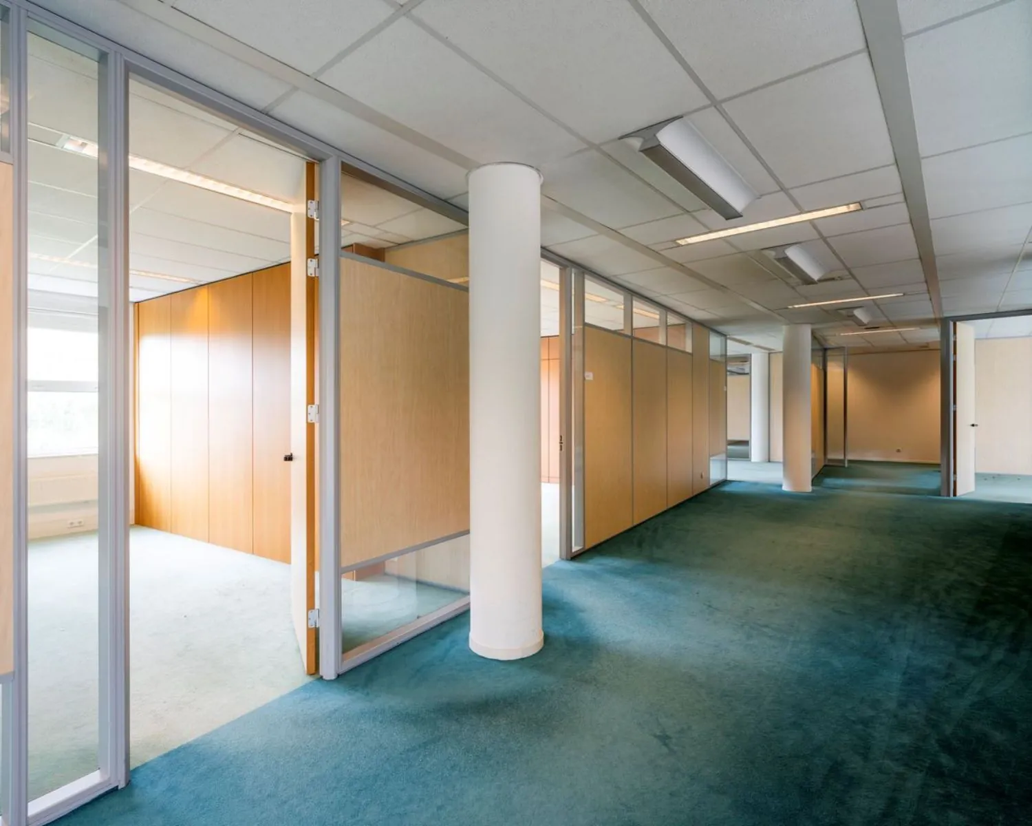 Moderne kantoorruimte met glazen wanden en tapijt, gelegen in Entrada 300 in Amsterdam.