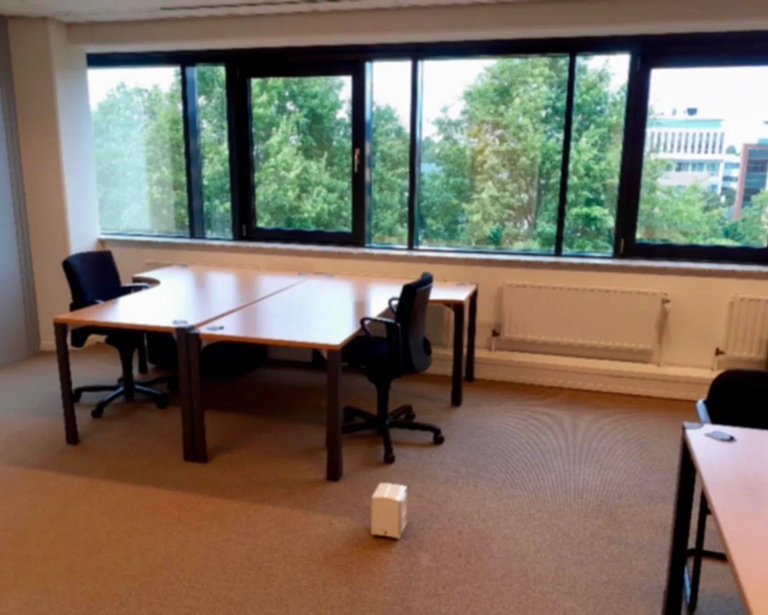 Kantoorruimte met bureaus en stoelen aan de Hardwareweg in Amersfoort met uitzicht op groen en kantoorgebouwen.