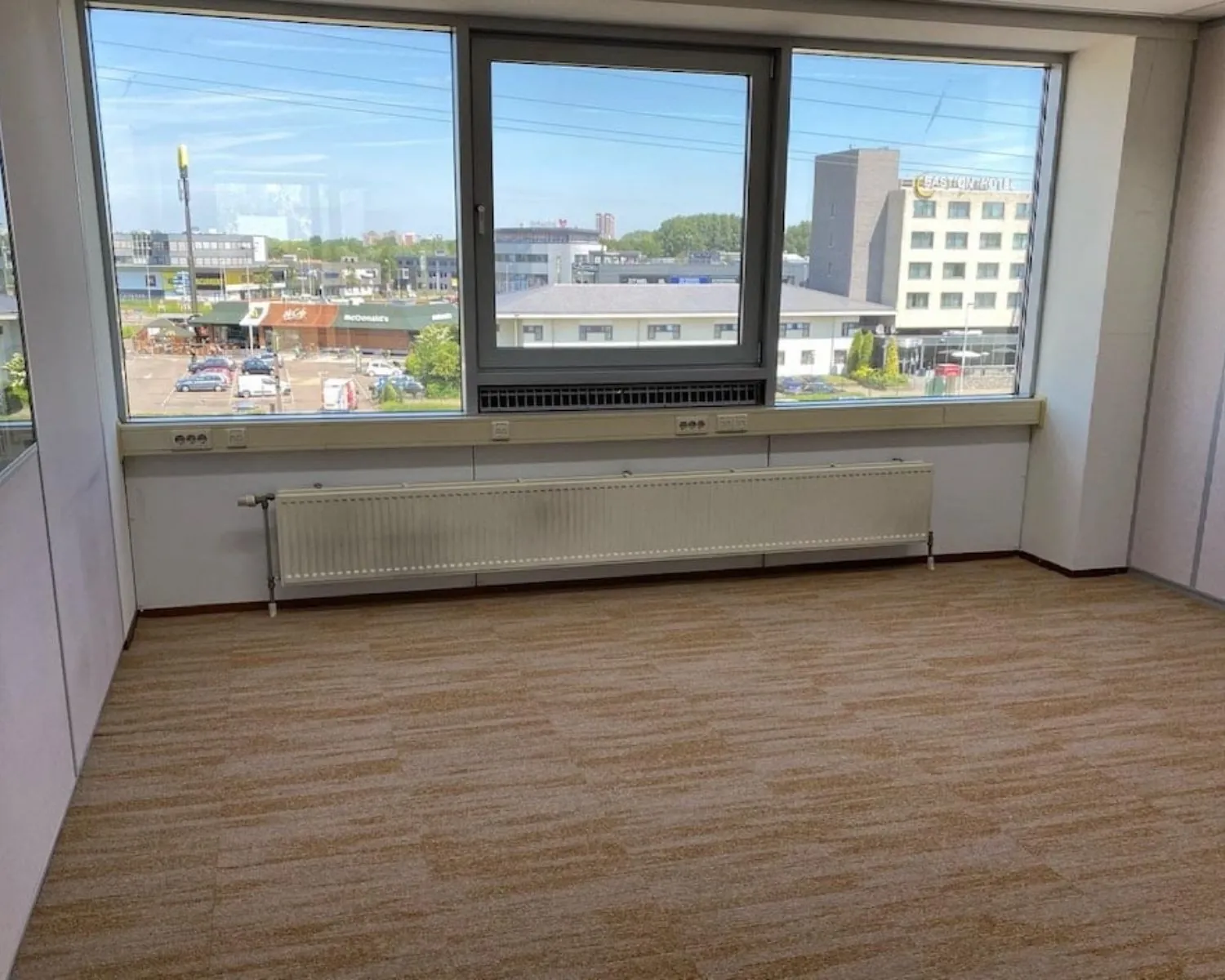 Lege kantoorruimte met tapijtvloer en grote ramen aan de Kamerlingh Onnesweg 10 in Barendrecht.