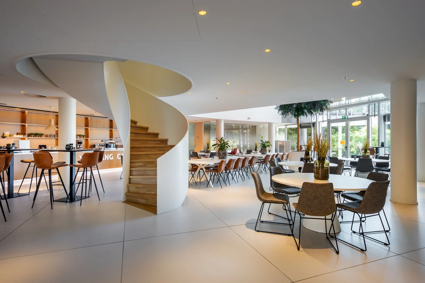 Moderne bedrijfsruimte aan de Euclideslaan met een open zithoek, ronde trap en veel natuurlijk licht.