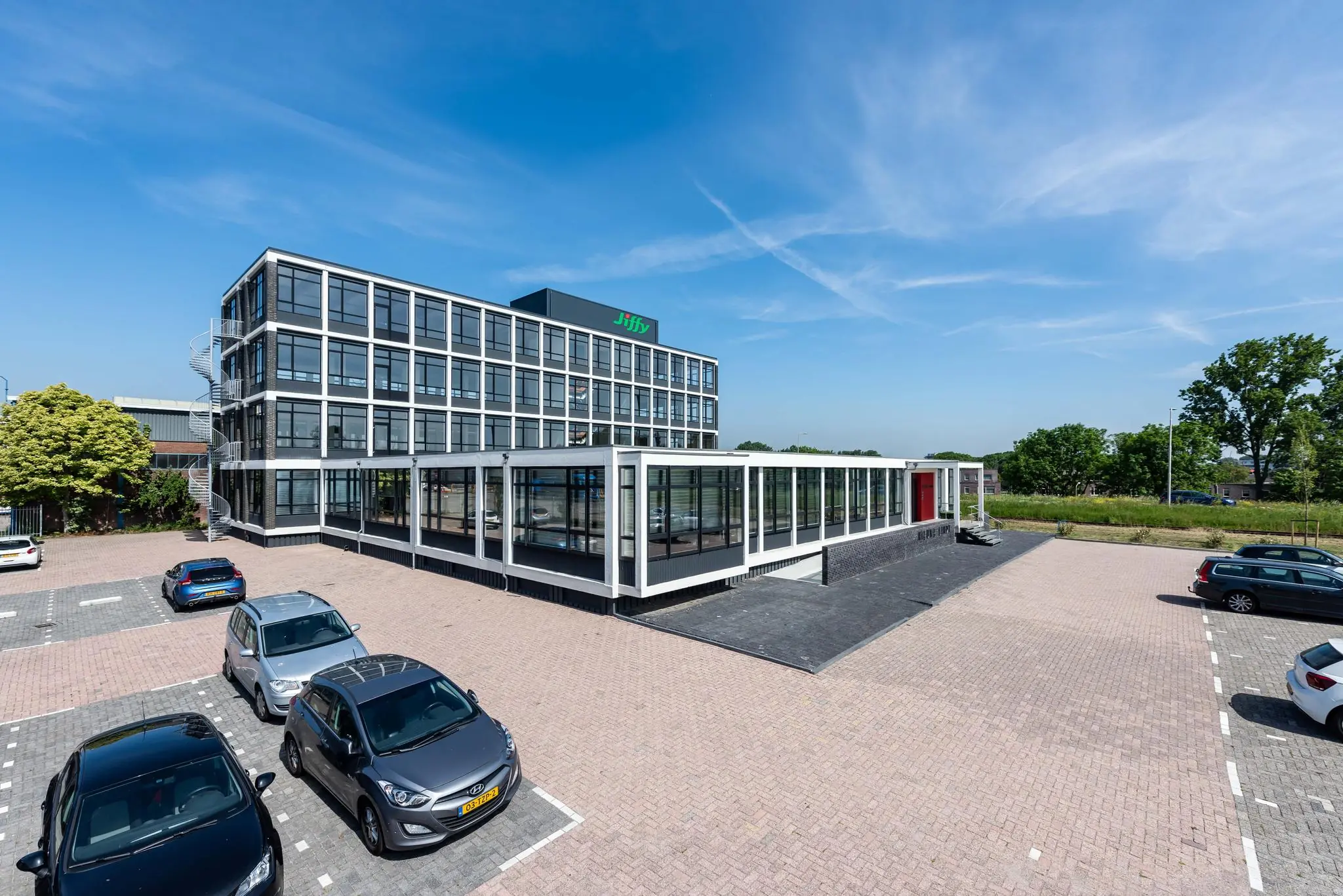 Modern kantoorgebouw aan de Lindtsedijk met glazen gevel en naastgelegen parkeerterrein.