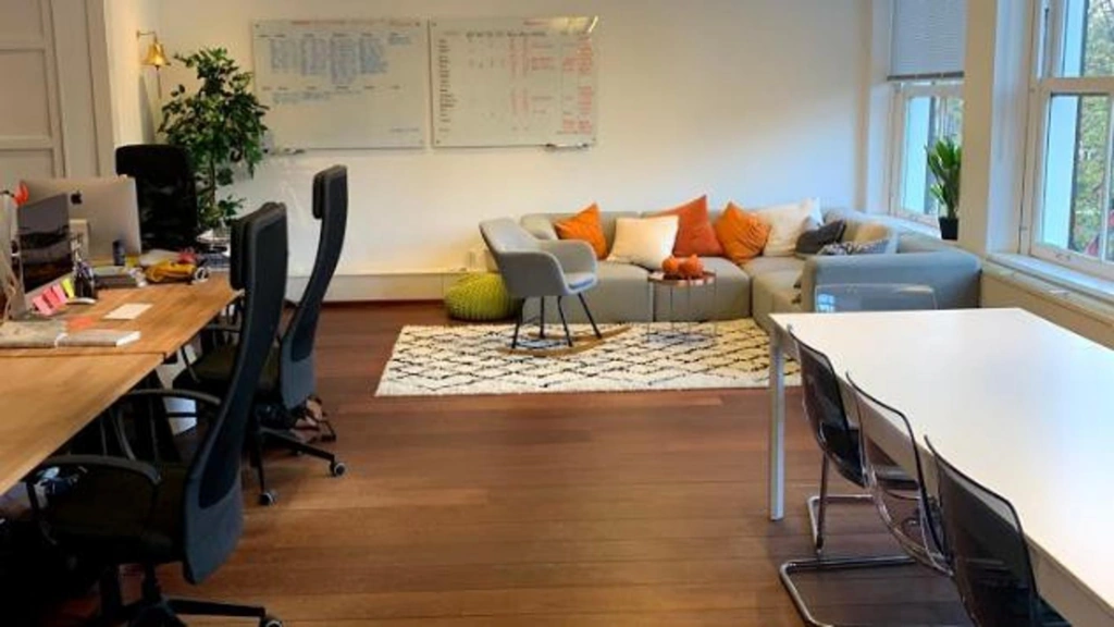 Modern kantoor aan de Keizersgracht met werkplekken, zithoek en grote ramen.