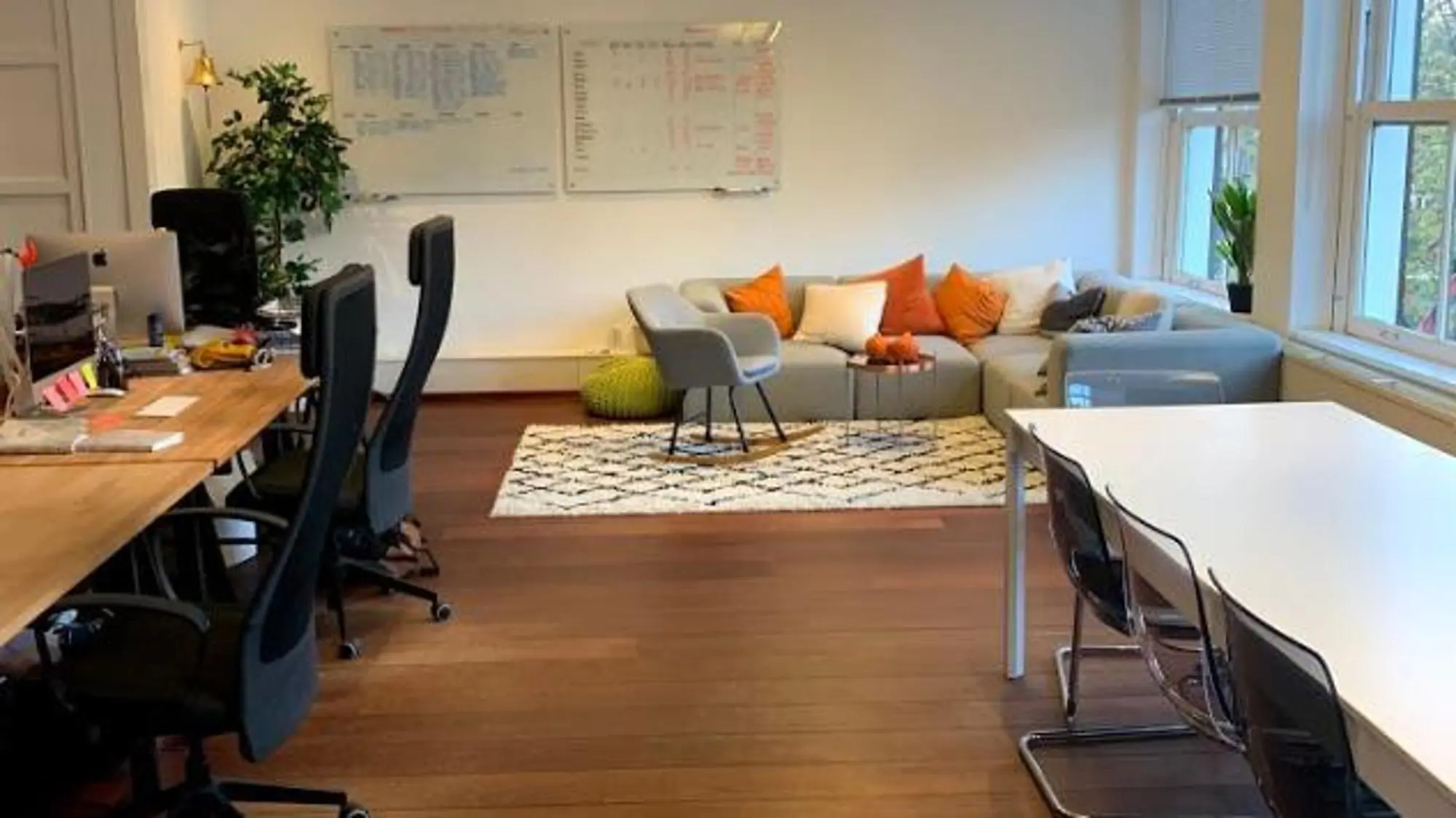 Modern kantoor aan de Keizersgracht met werkplekken, zithoek en grote ramen.