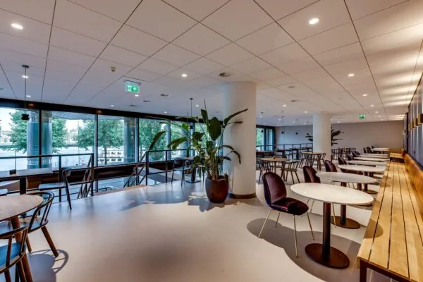 Moderne en ruim opgezette horecaruimte aan de Boompjes met grote ramen en uitzicht op de rivier.