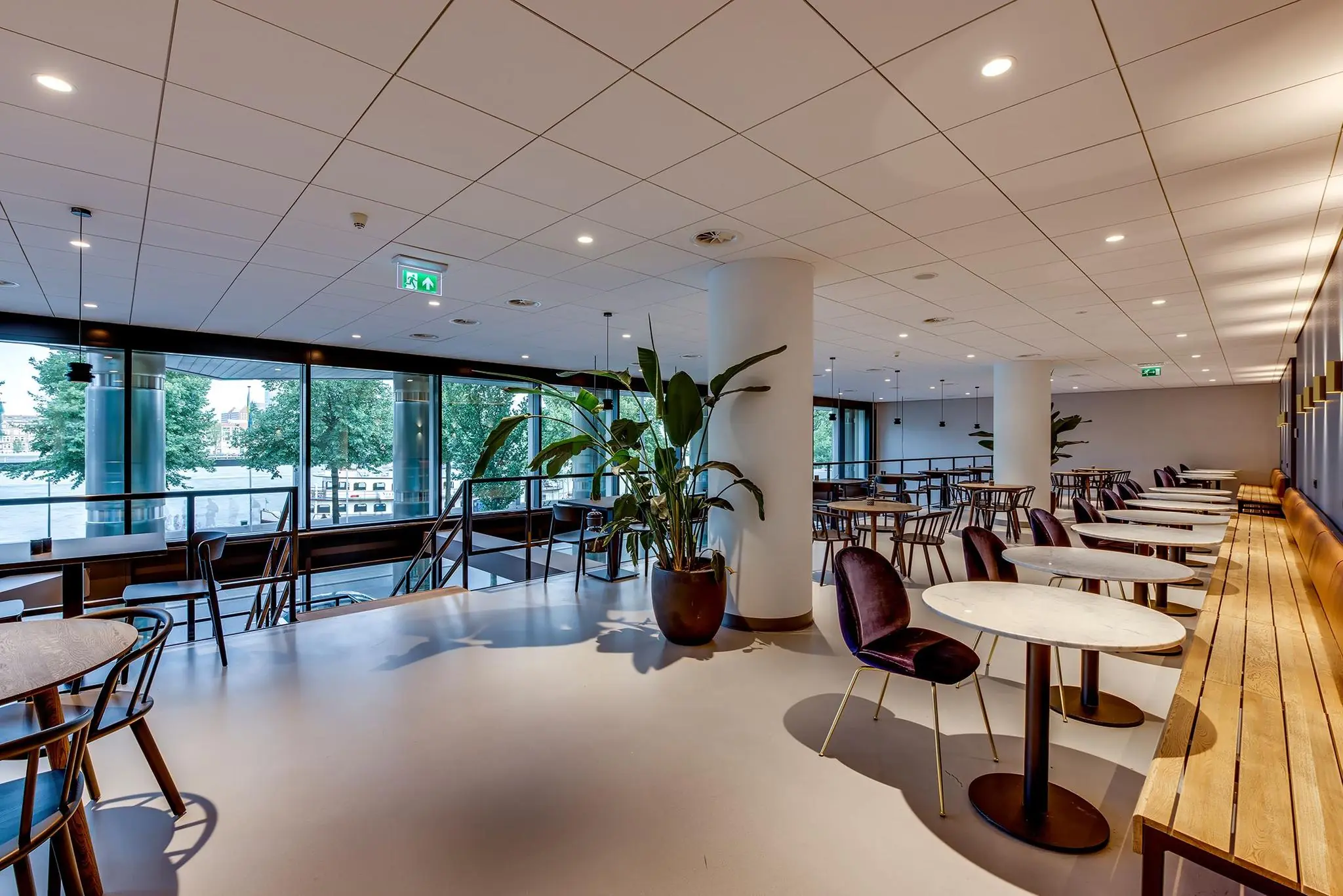 Moderne en ruim opgezette horecaruimte aan de Boompjes met grote ramen en uitzicht op de rivier.