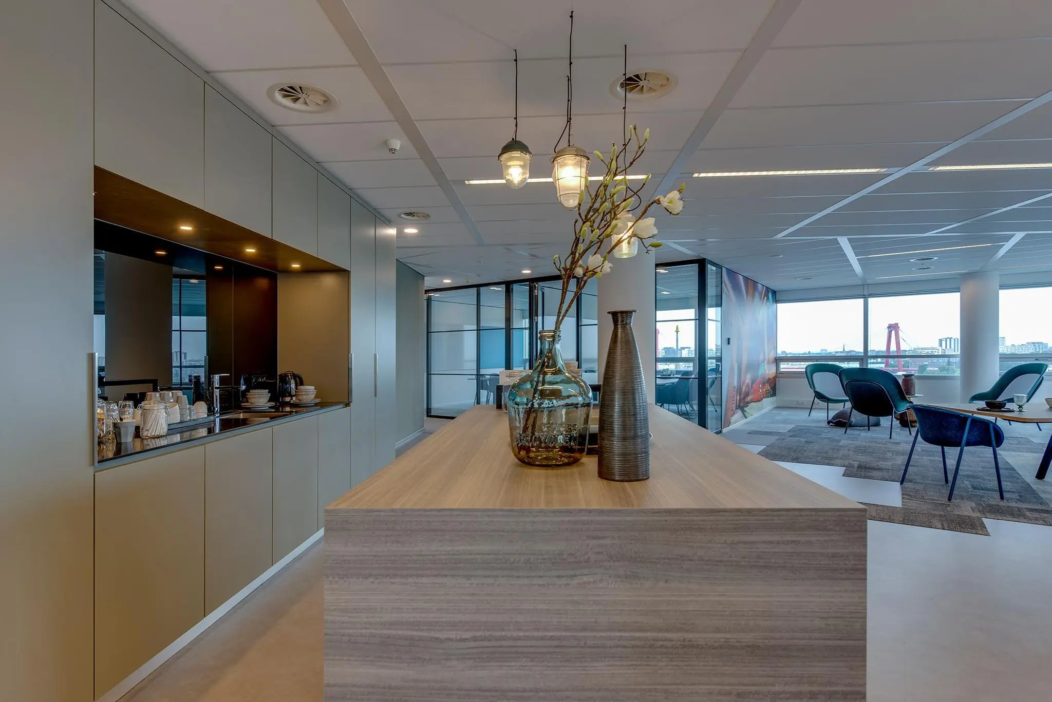 Modern kantoorinterieur aan de Boompjes met zithoek, grote ramen en uitzicht op de Willemsbrug in Rotterdam.