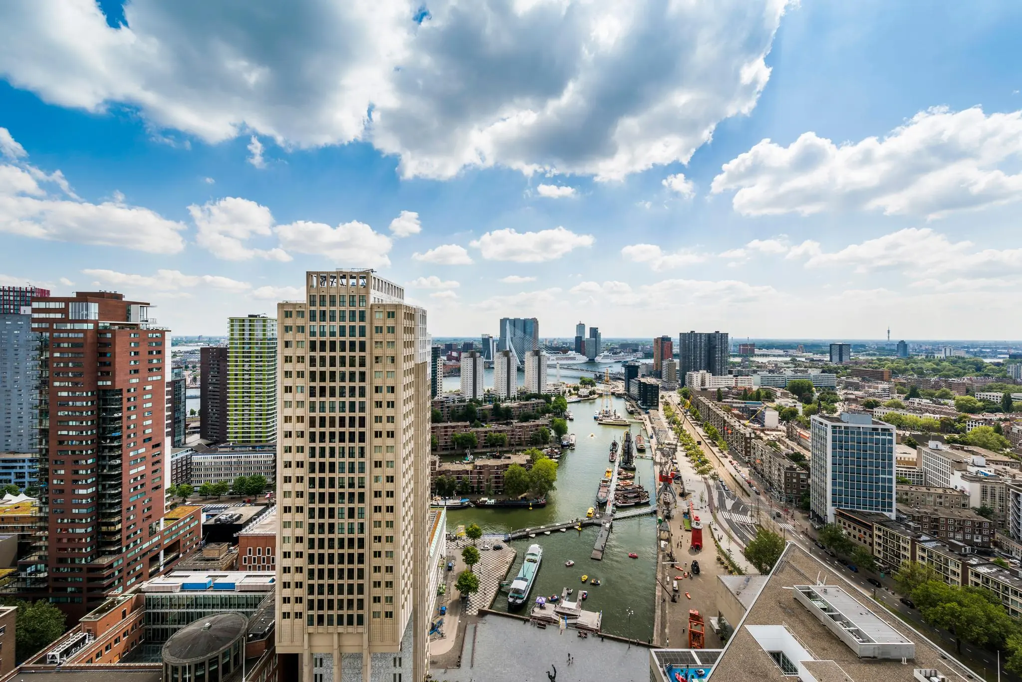 Luchtfoto van de Blaak in Rotterdam met uitzicht op hoge gebouwen, de Wijnhaven en de skyline langs de rivier.