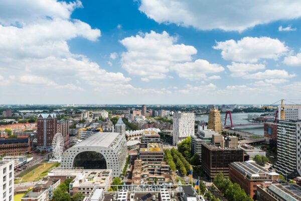 Luchtfoto van het centrum van Rotterdam met de Markthal, kubuswoningen en de Willemsbrug.