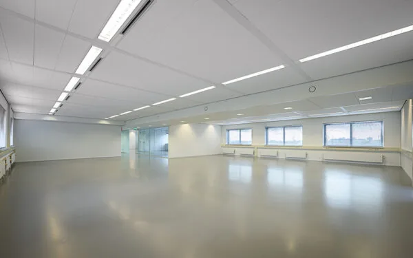 Lichte, lege kantoorruimte aan de Essebaan met grote ramen en een glazen wand.