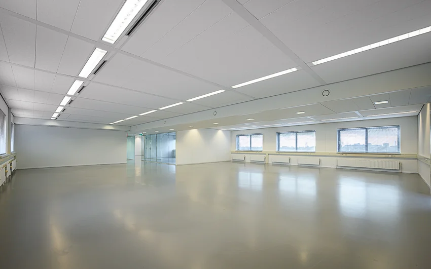 Lichte, lege kantoorruimte aan de Essebaan met grote ramen en een glazen wand.