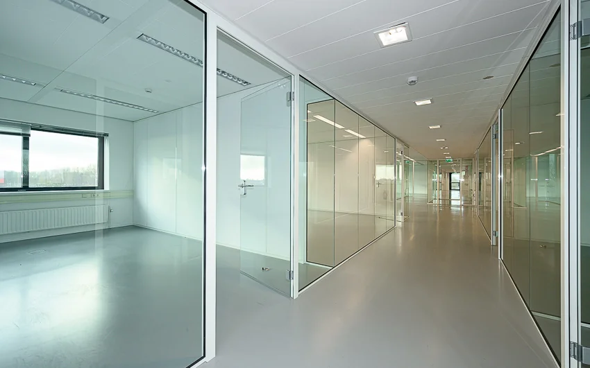 Moderne, lichte kantoorruimte aan de Essebaan met glazen wanden en een lange gang.