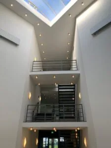 Moderne licht atrium met metalen trappen en een glazen dak in een gebouw aan de Zekeringstraat.