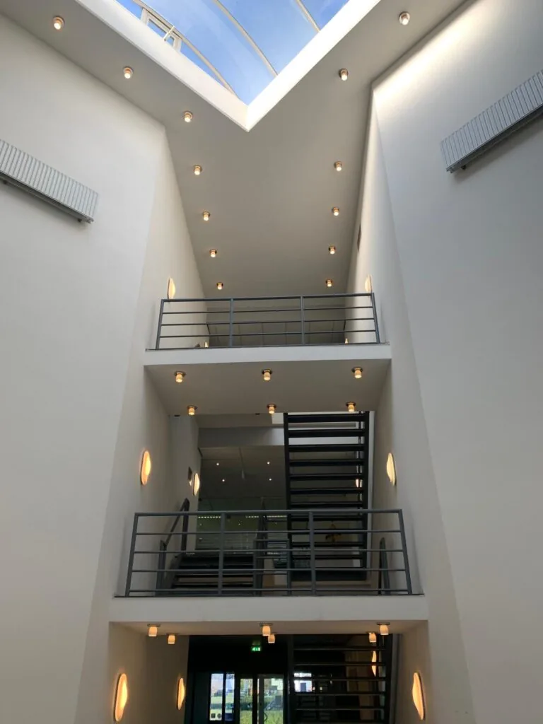 Moderne licht atrium met metalen trappen en een glazen dak in een gebouw aan de Zekeringstraat.