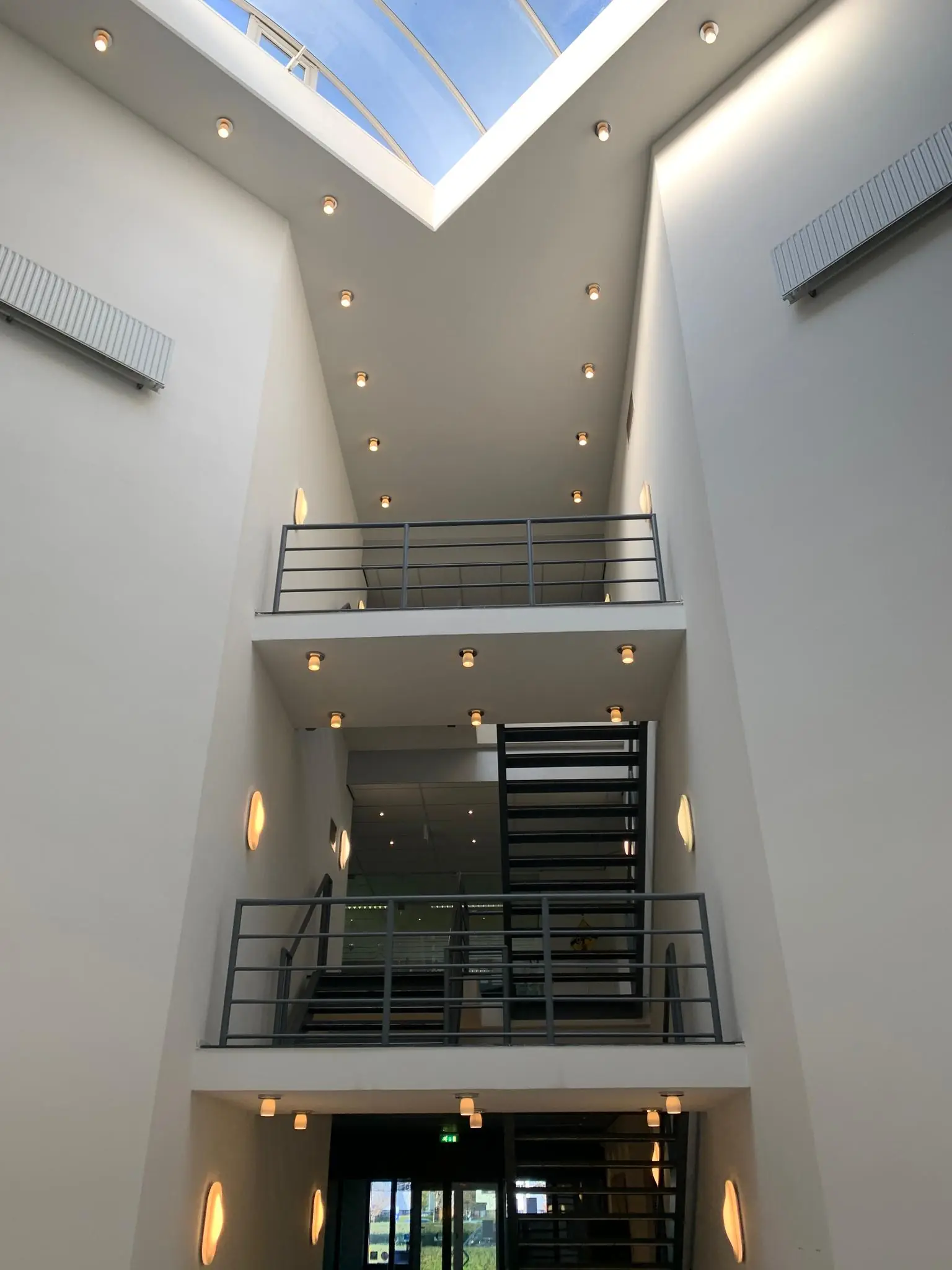 Moderne licht atrium met metalen trappen en een glazen dak in een gebouw aan de Zekeringstraat.
