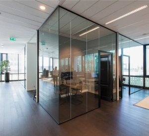 Modern kantoorinterieur aan de Herikerbergweg met glazen vergaderruimtes en houten vloer.