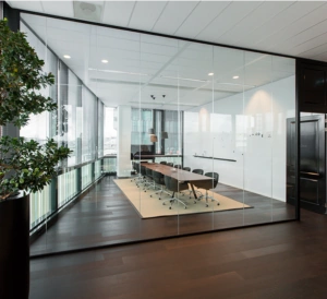 Vergaderruimte met glazen wanden, een lange houten tafel en moderne bureaustoelen aan de Herikerbergweg.