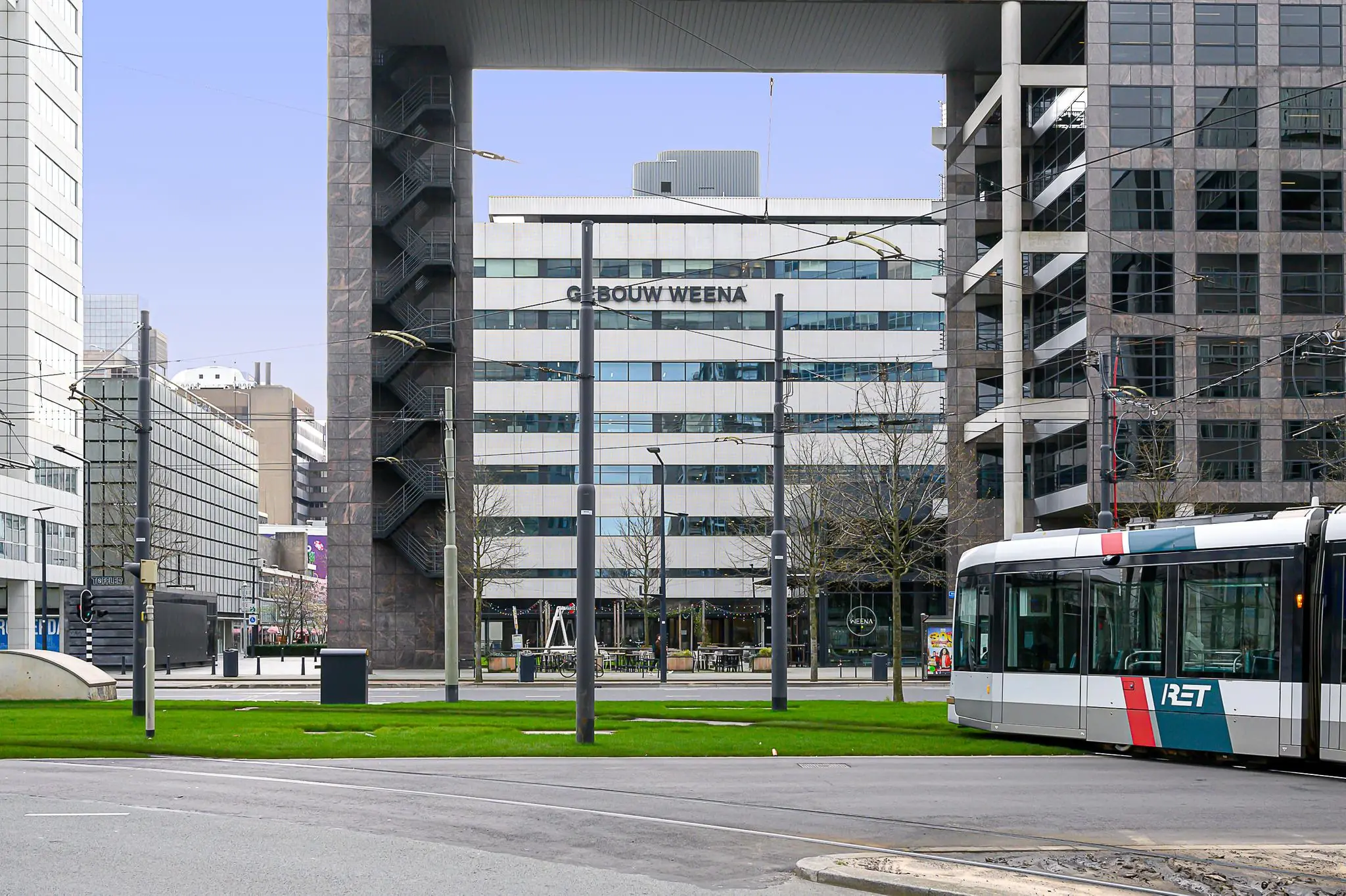 Straatbeeld van Weena-Zuid in Rotterdam met een RET-tram en het kantoorgebouw 'Gebouw Weena' op de achtergrond.