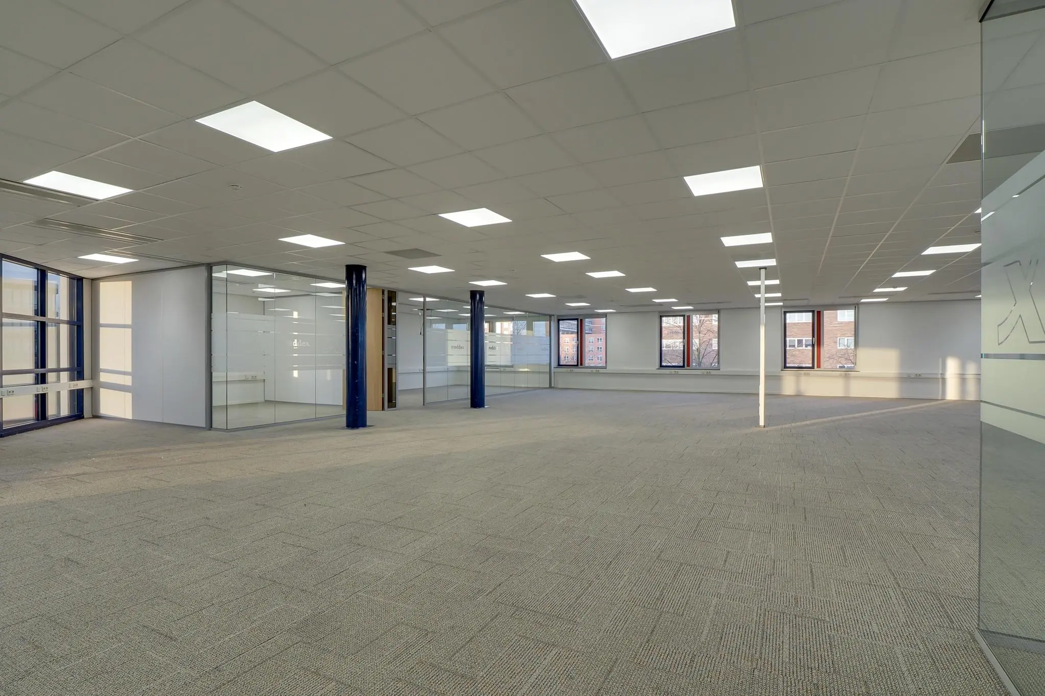 Ruim, modern kantoorpand aan de Rijnzathe met glazen wanden en systeemplafond.