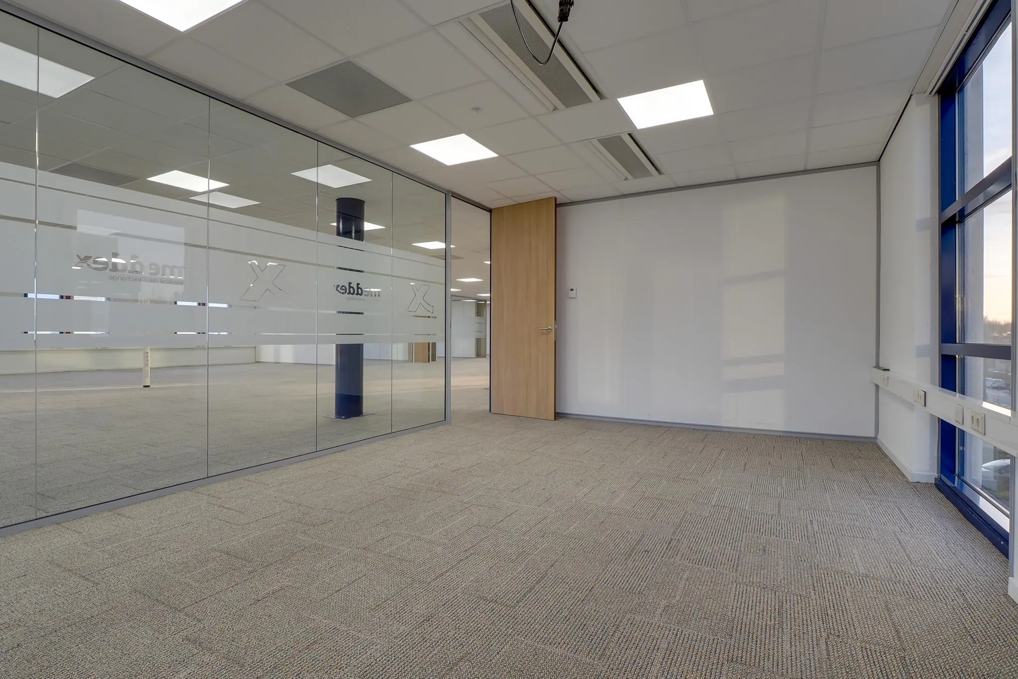 Leeg kantoorpand aan de Rijnzathe met glazen scheidingswanden en blauw kozijn.