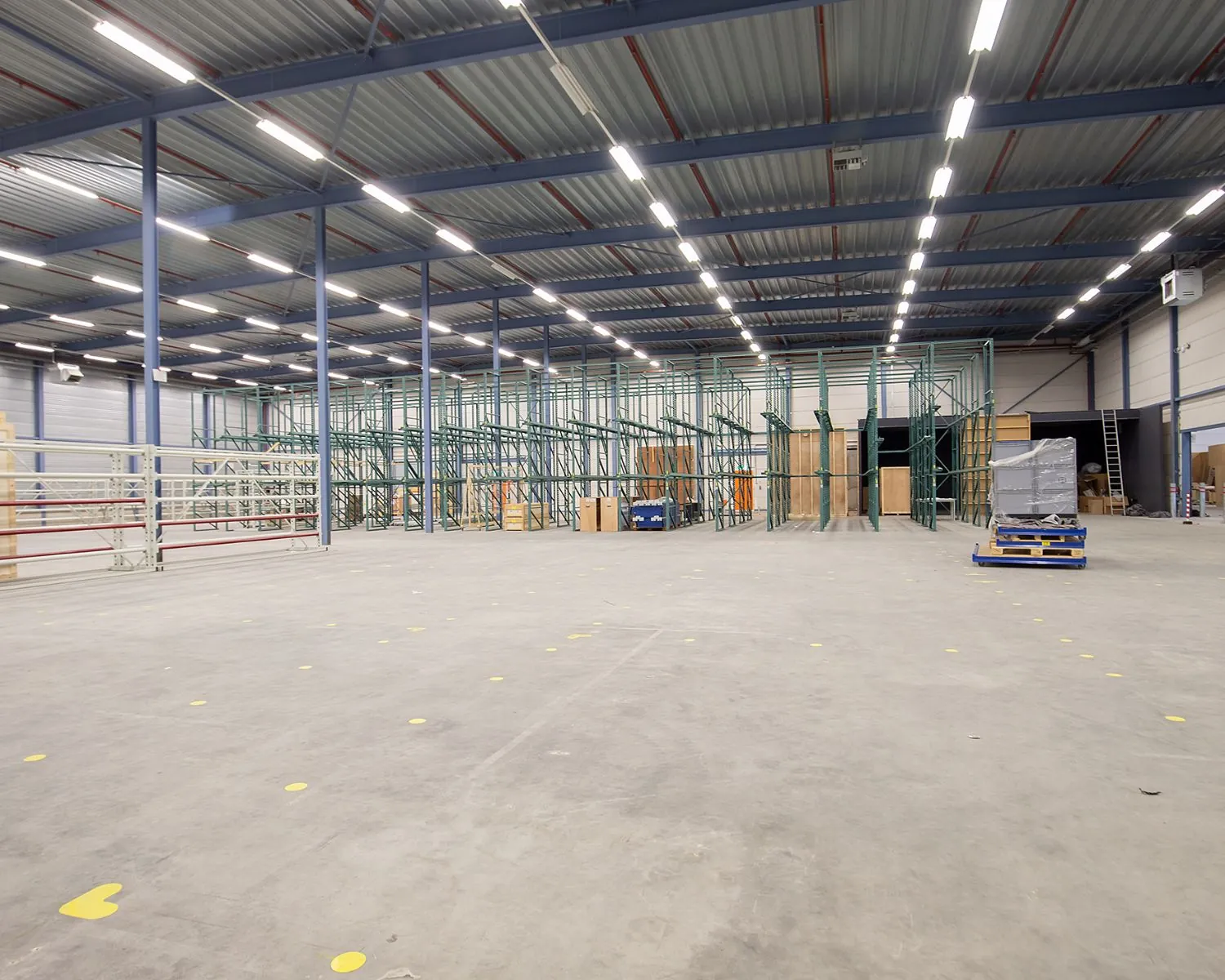 Ruime, lege bedrijfshal met hoge stellingen aan de Albert Einsteinweg 5 in Lelystad.