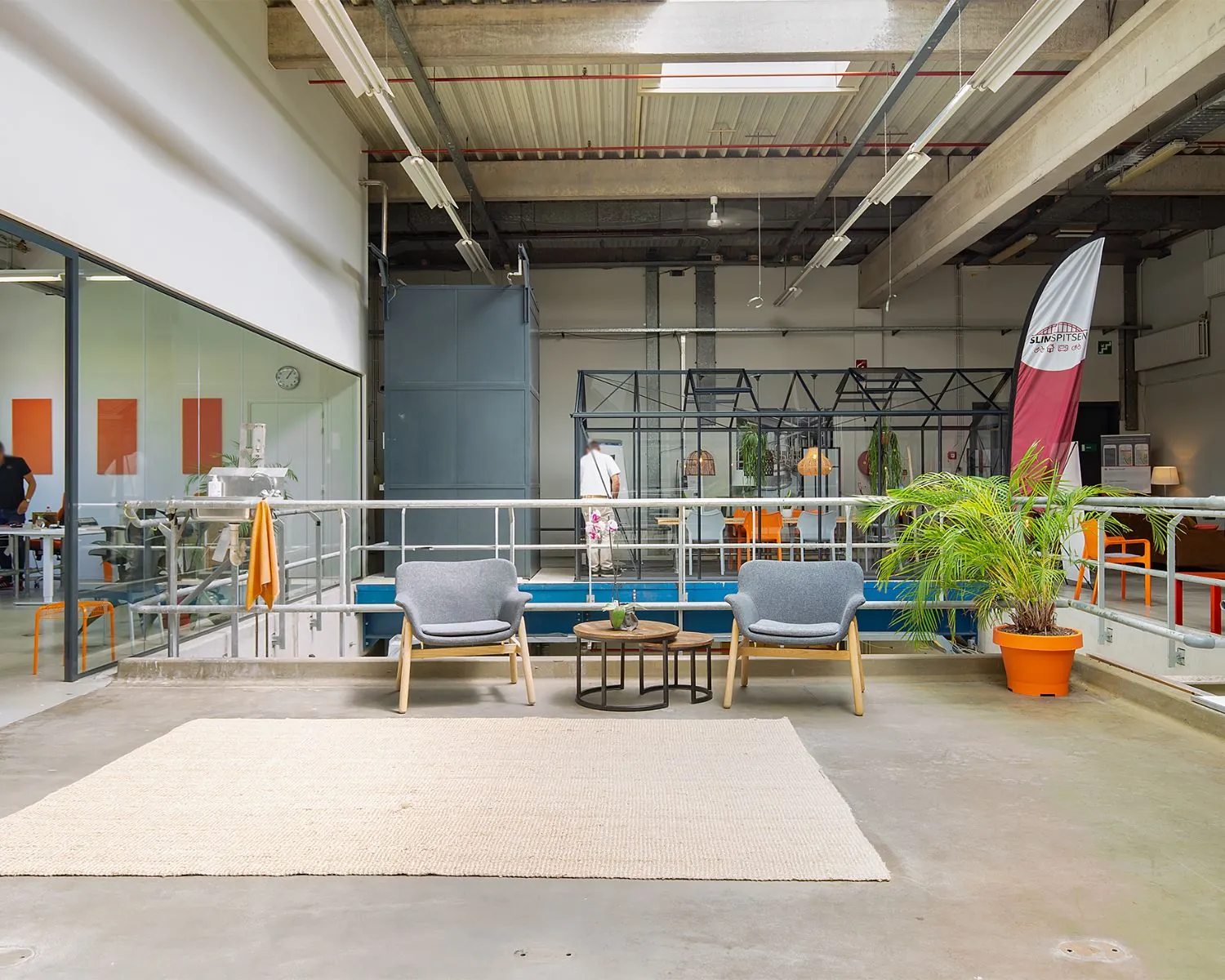 Moderne, open kantoorruimte aan de Bolderweg 2 in Almere met een loungegedeelte, glazen vergaderruimte en industriële elementen.