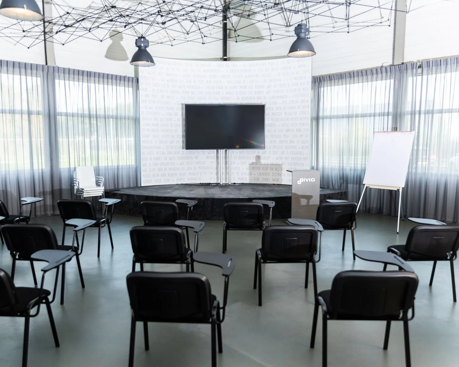 Moderne vergaderruimte aan de Pascallaan 60-78 in Lelystad met stoelen, presentatiescherm, katheder en flip-over.