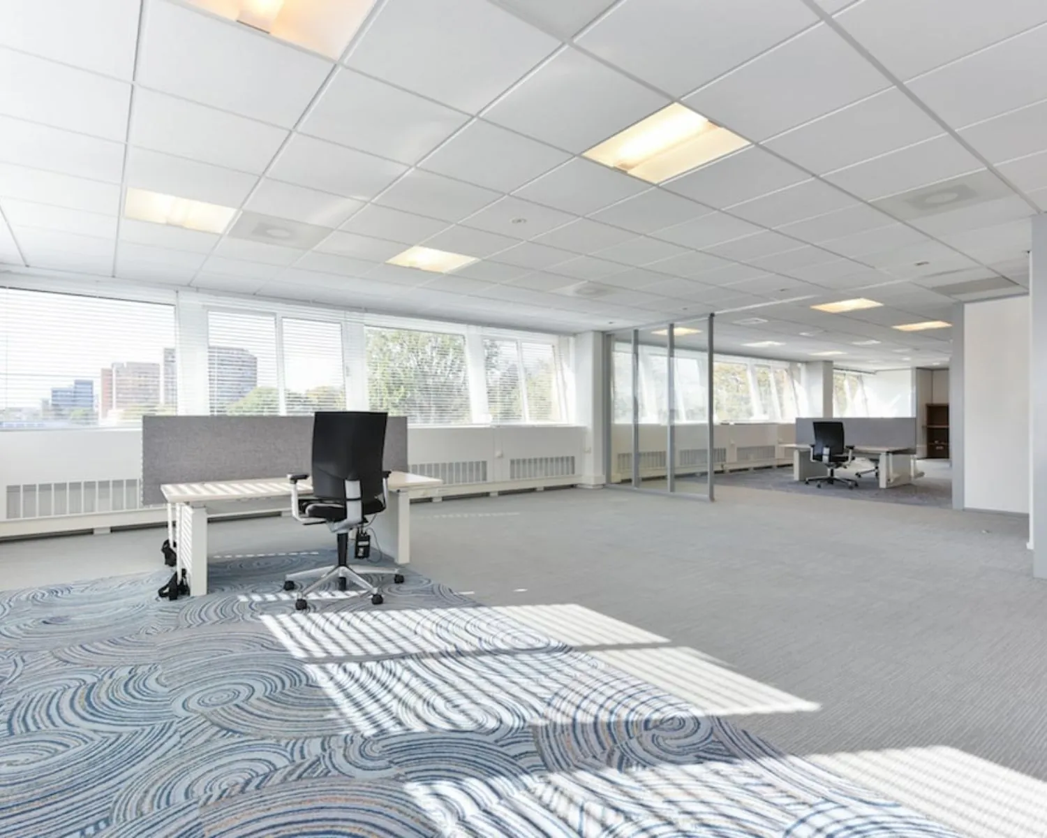 Lichte en ruime kantoorruimte met werkplekken en grote ramen aan de Treubstraat 1 in Rijswijk.