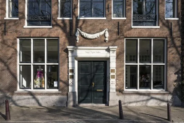 Voorgevel van een historisch pand aan de Leidsegracht met grote ramen en een dubbele donkergroene deur.