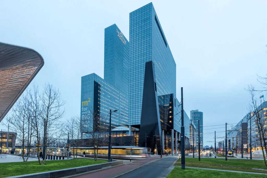 Modern kantoorgebouw aan het Weena in Rotterdam met voorbijrijdende tram op de voorgrond.