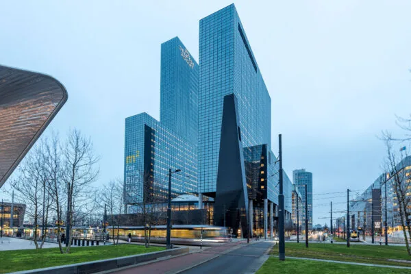 Modern kantoorgebouw aan het Weena in Rotterdam met voorbijrijdende tram op de voorgrond.