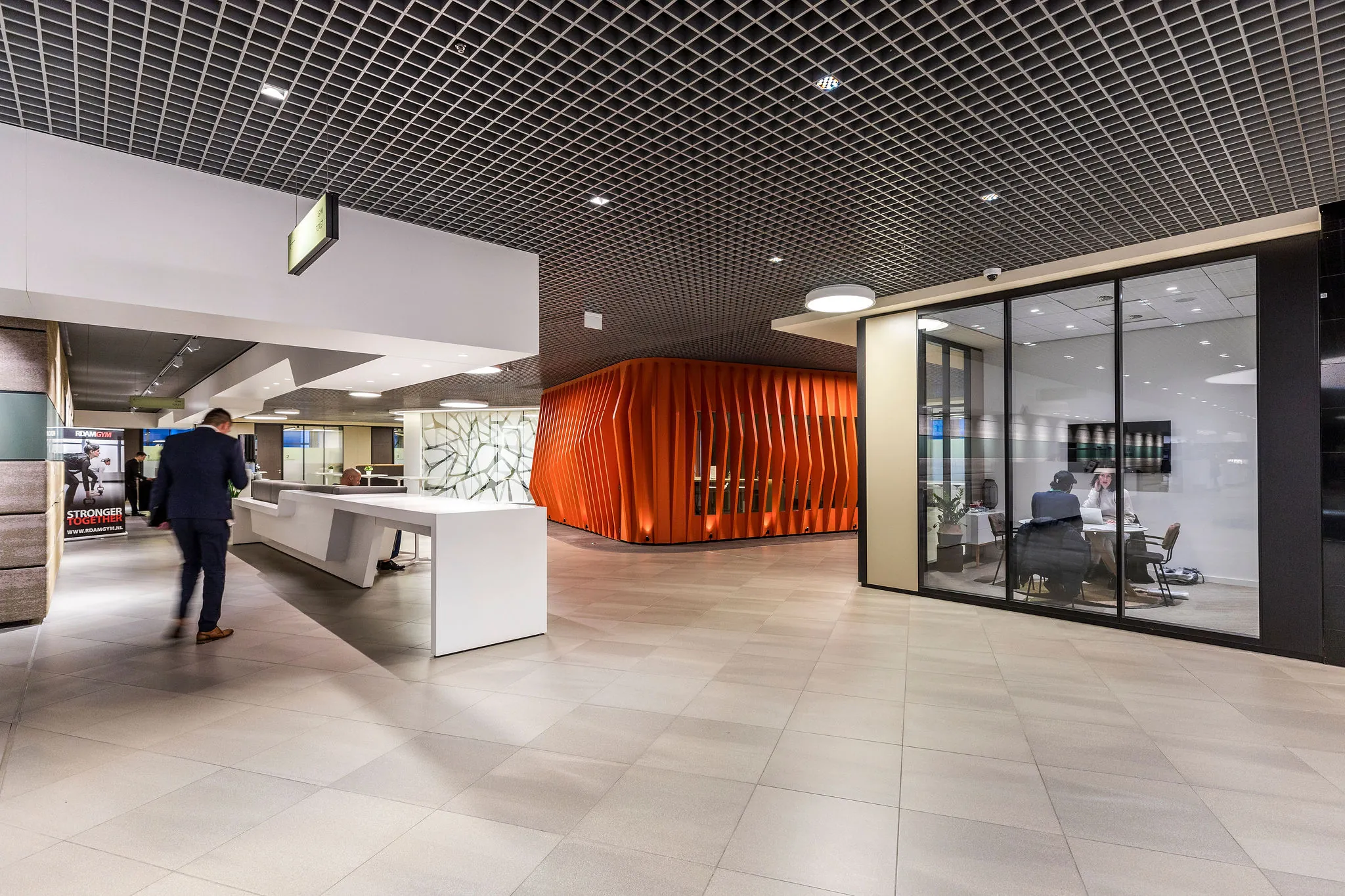 Moderne kantoorlobby aan het Weena met een opvallend oranje vergaderpaviljoen en glazen vergaderruimte.