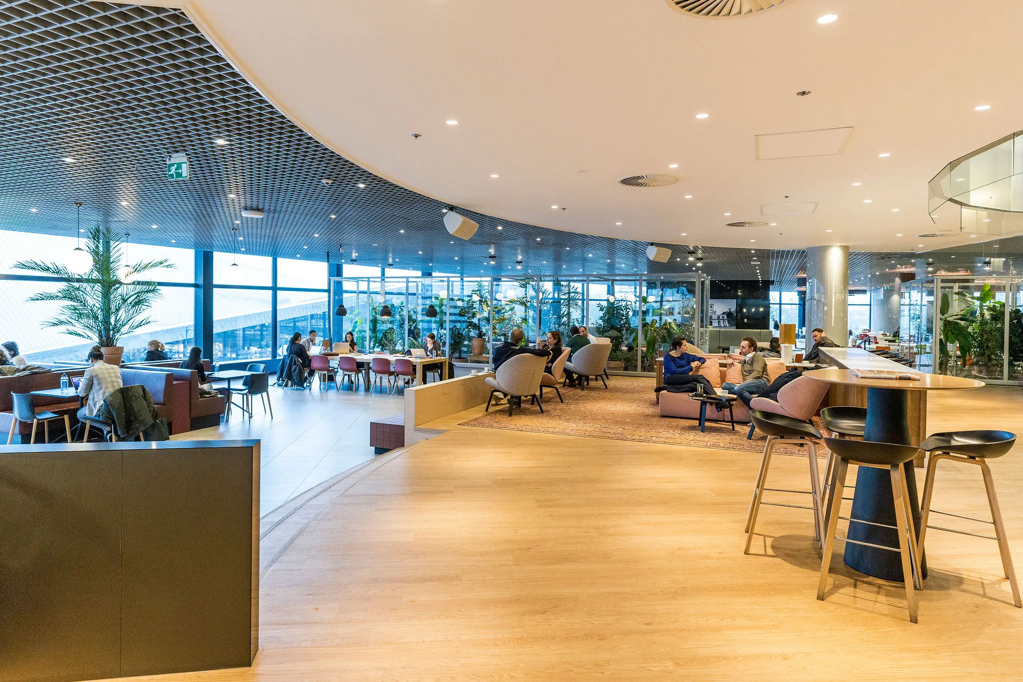 Moderne lounge- en werkruimte in het Weena-gebouw met mensen die ontspannen en werken.