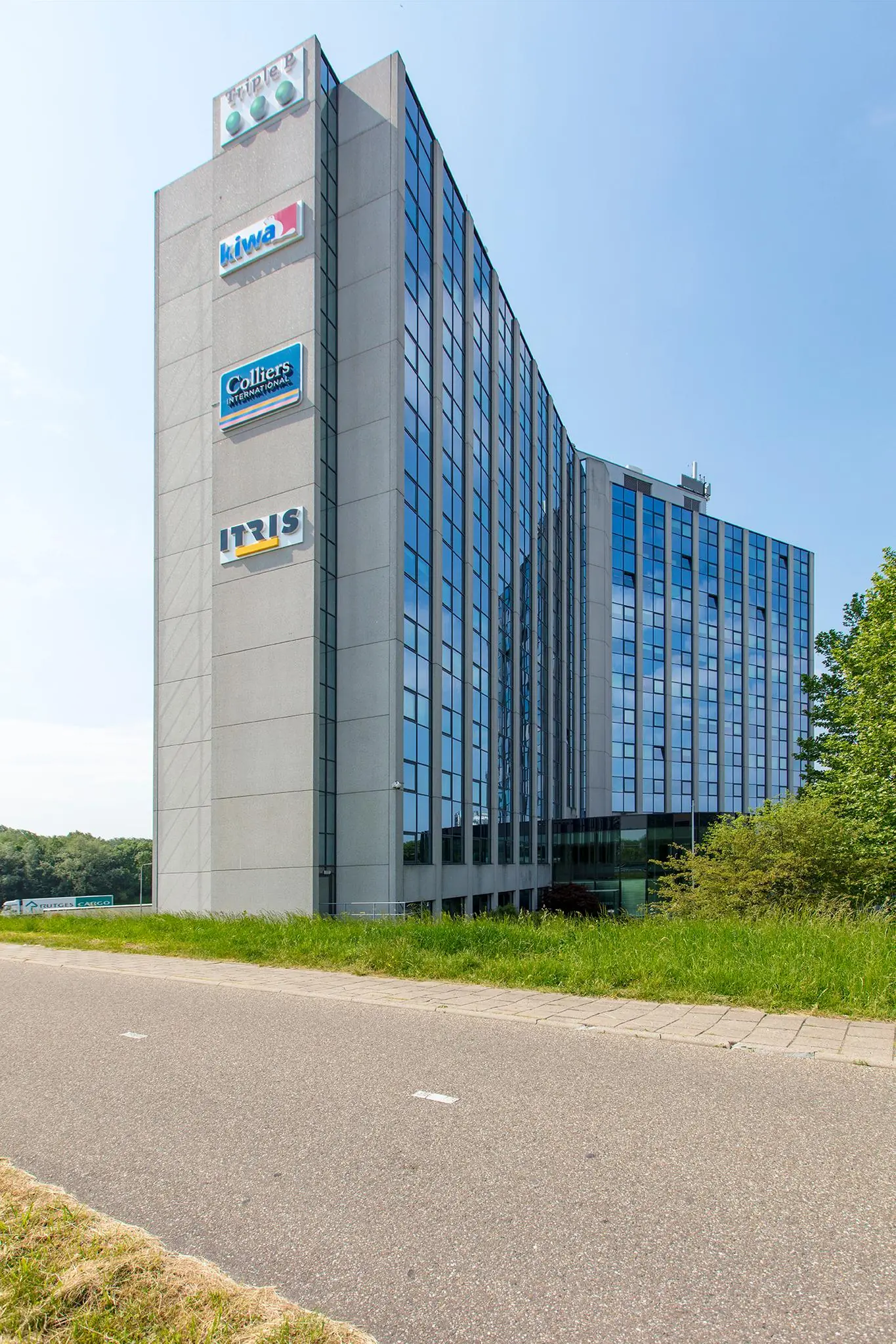 Modern kantoorgebouw aan de Nevelgaarde met logo’s van bedrijven zoals Triple P, Kiwa, Colliers International en IT RIS.