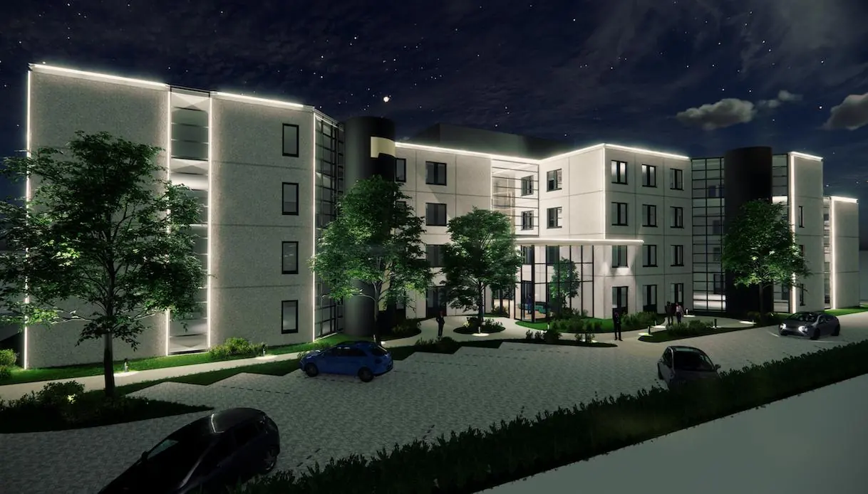 Sfeervolle nachtimpressie van het moderne kantoorgebouw Rijnzathe met verlichte gevel en omliggend groen.