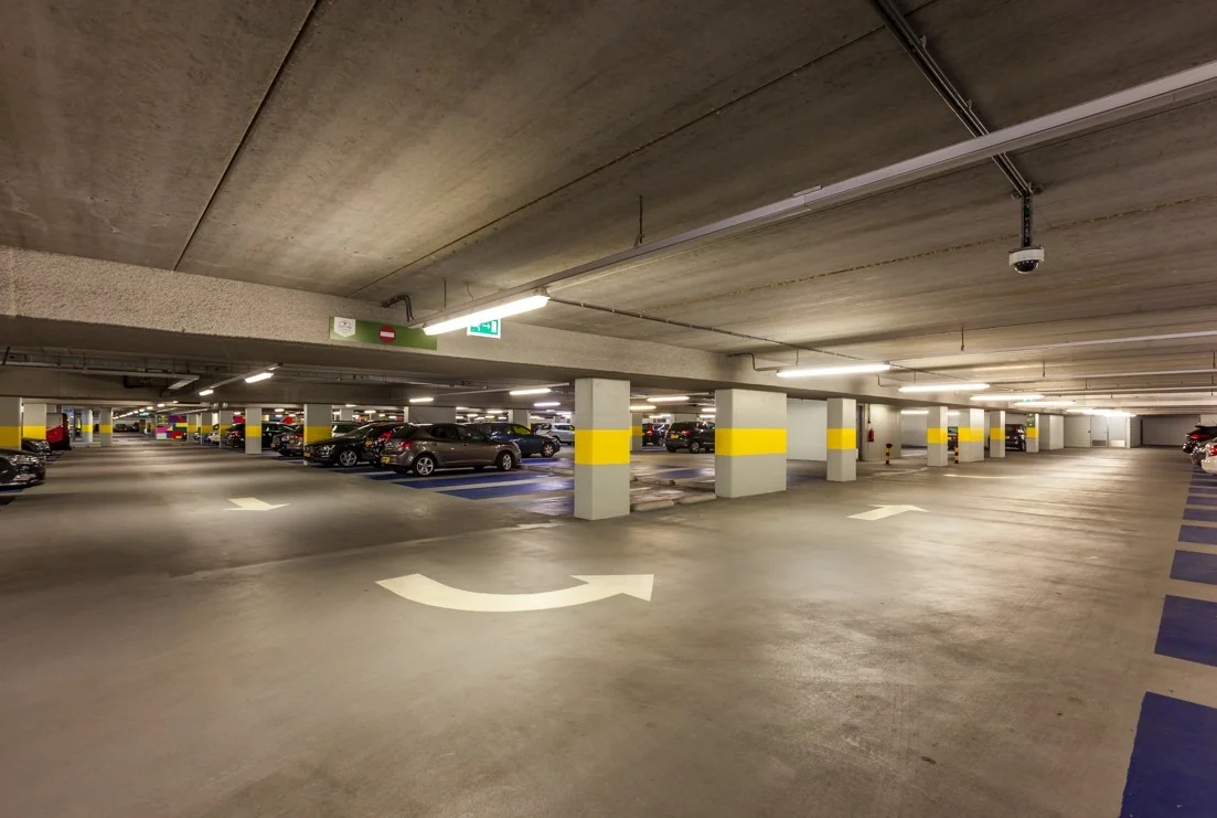 Ondergrondse parkeergarage aan de Orteliuslaan met geparkeerde auto's en gele markeringen op de pilaren.