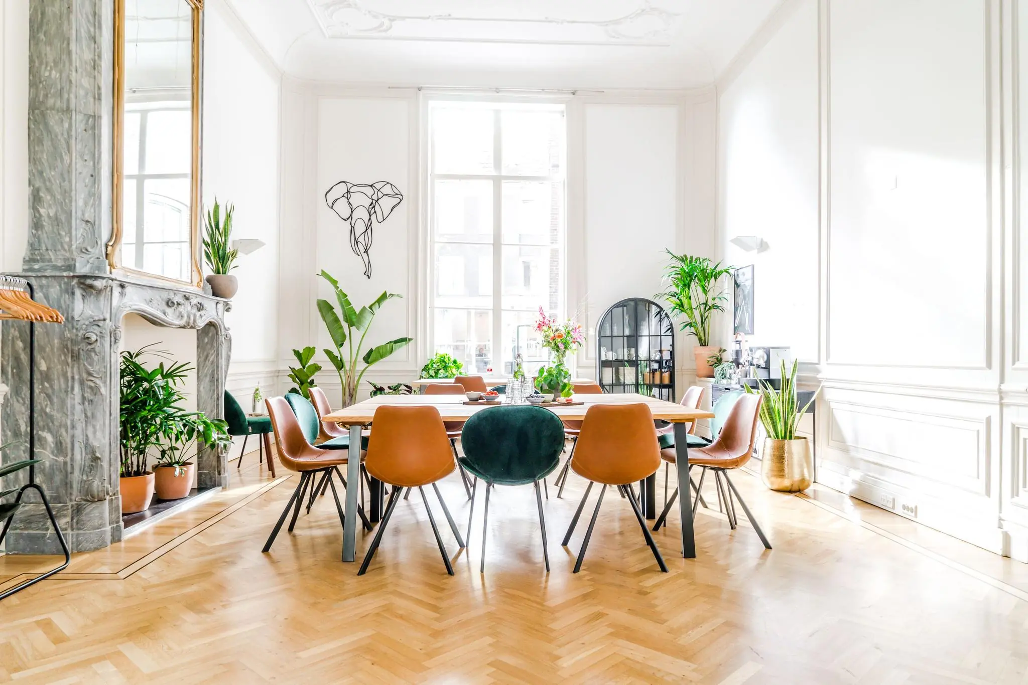 Stijlvol ingerichte vergaderruimte aan de Herengracht met een grote houten tafel, designstoelen en veel groene planten.