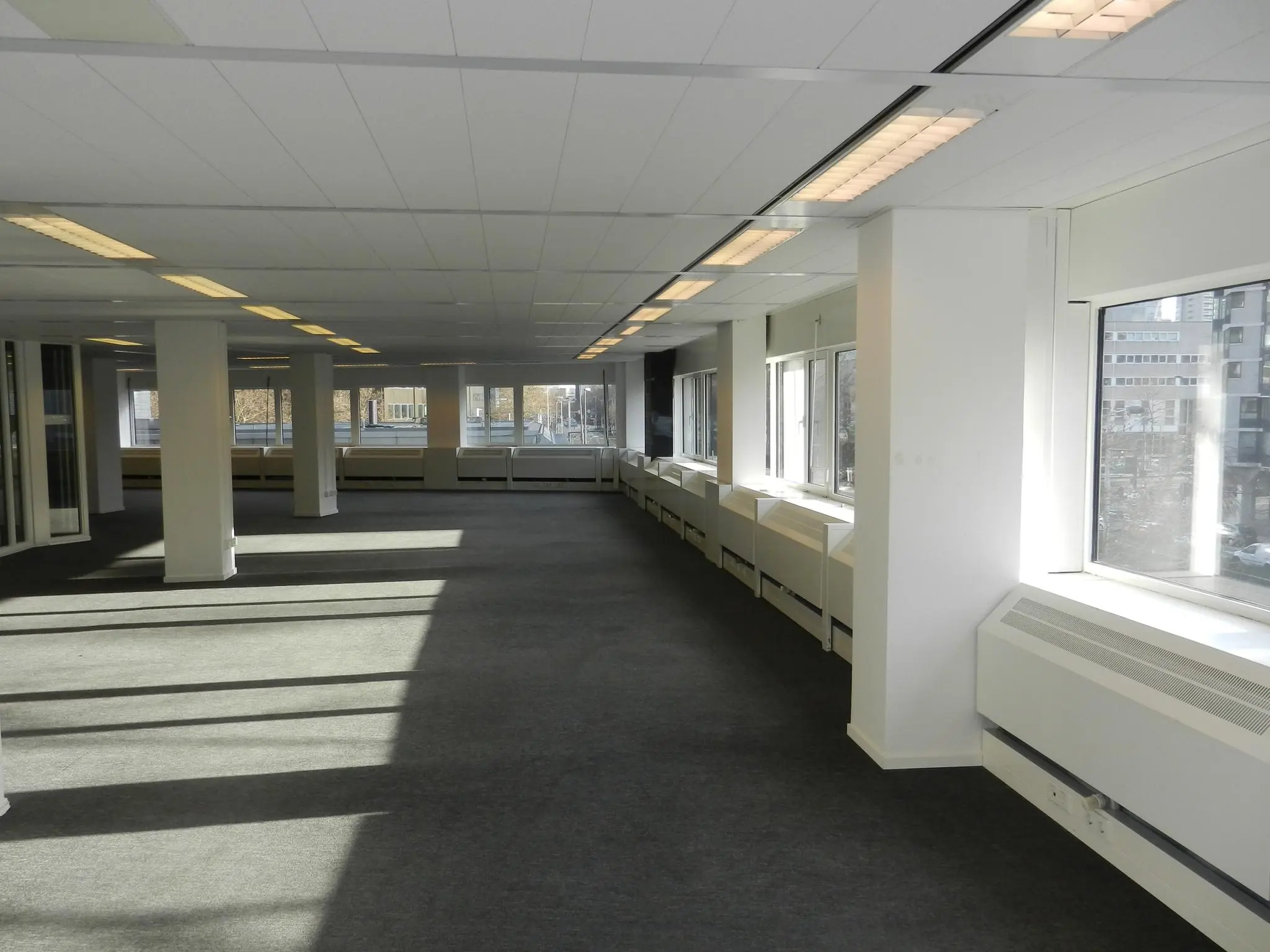 Leeg, modern kantoorpand aan de Westblaak met grote ramen en systeemplafond.
