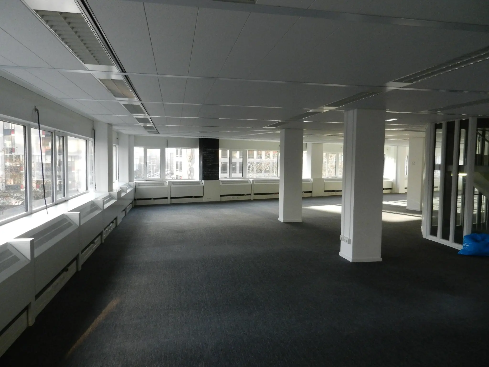 Leeg kantoorpand aan de Westblaak met grote ramen en witte pilaren.
