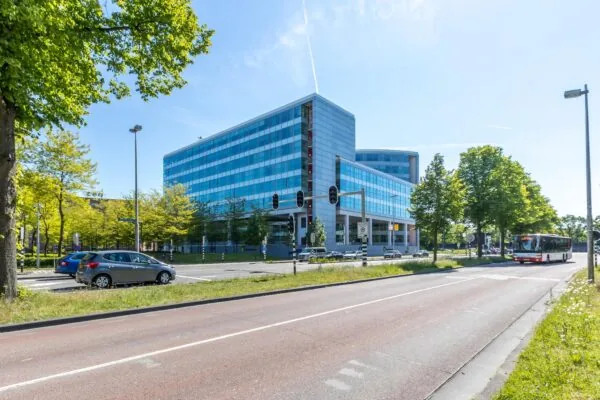 Modern kantoorgebouw aan de Newtonlaan in Utrecht, gezien vanaf de straat met verkeer en openbaar vervoer.