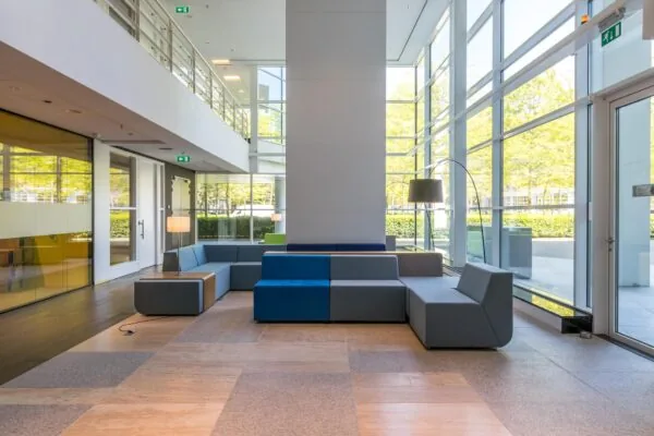 Modern ingerichte wachtruimte met kleurrijke modulaire zitbanken in een licht en ruim kantoorpand aan de Newtonlaan.