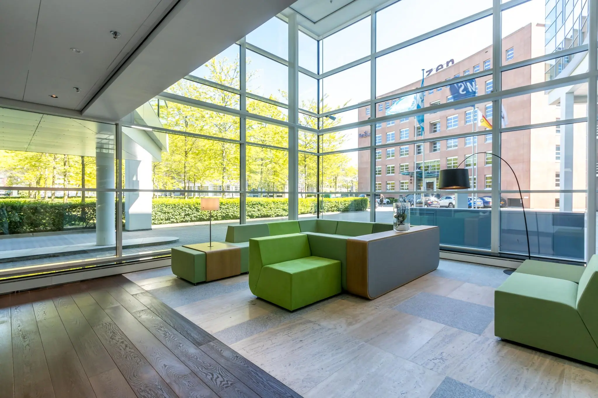 Moderne wachtruimte met groene zitbanken en grote ramen aan de Newtonlaan.