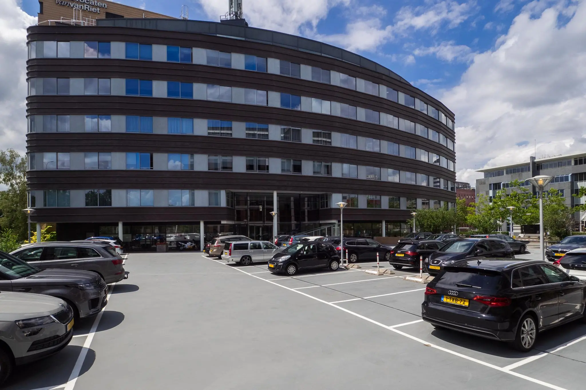 Parkeerterrein met geparkeerde auto's voor het kantoorgebouw aan de Euclideslaan in Utrecht.