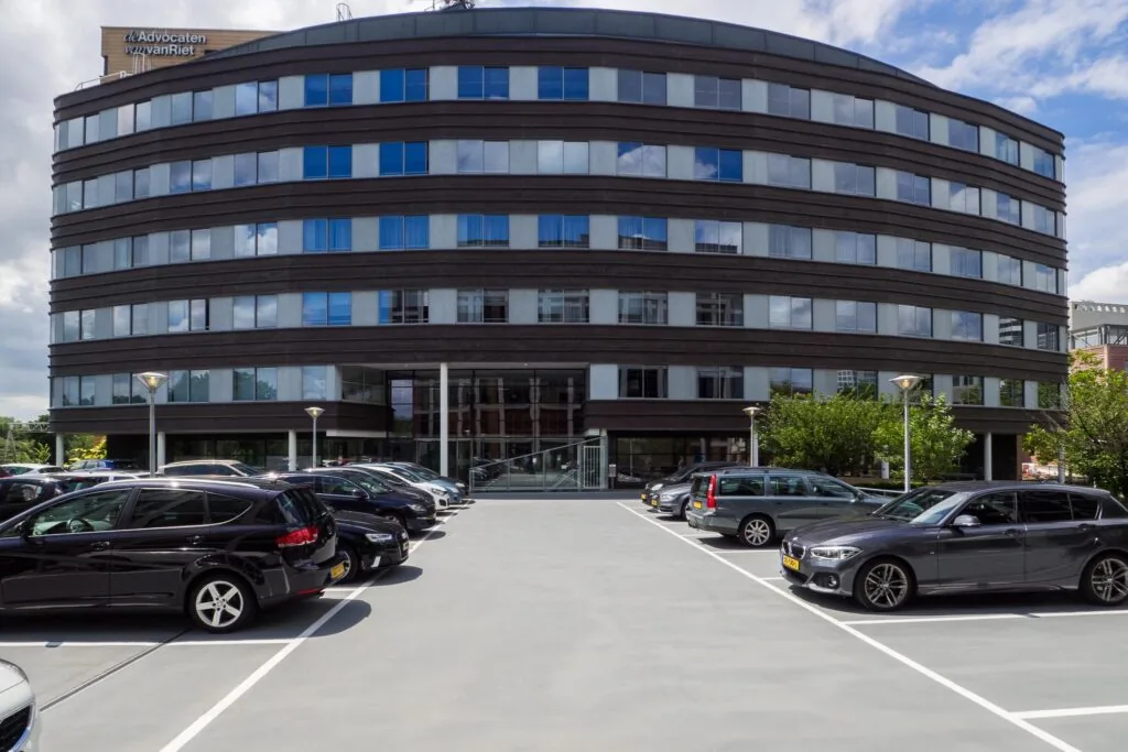 Kantoorpand aan de Euclideslaan met parkeerplaatsen op de voorgrond.