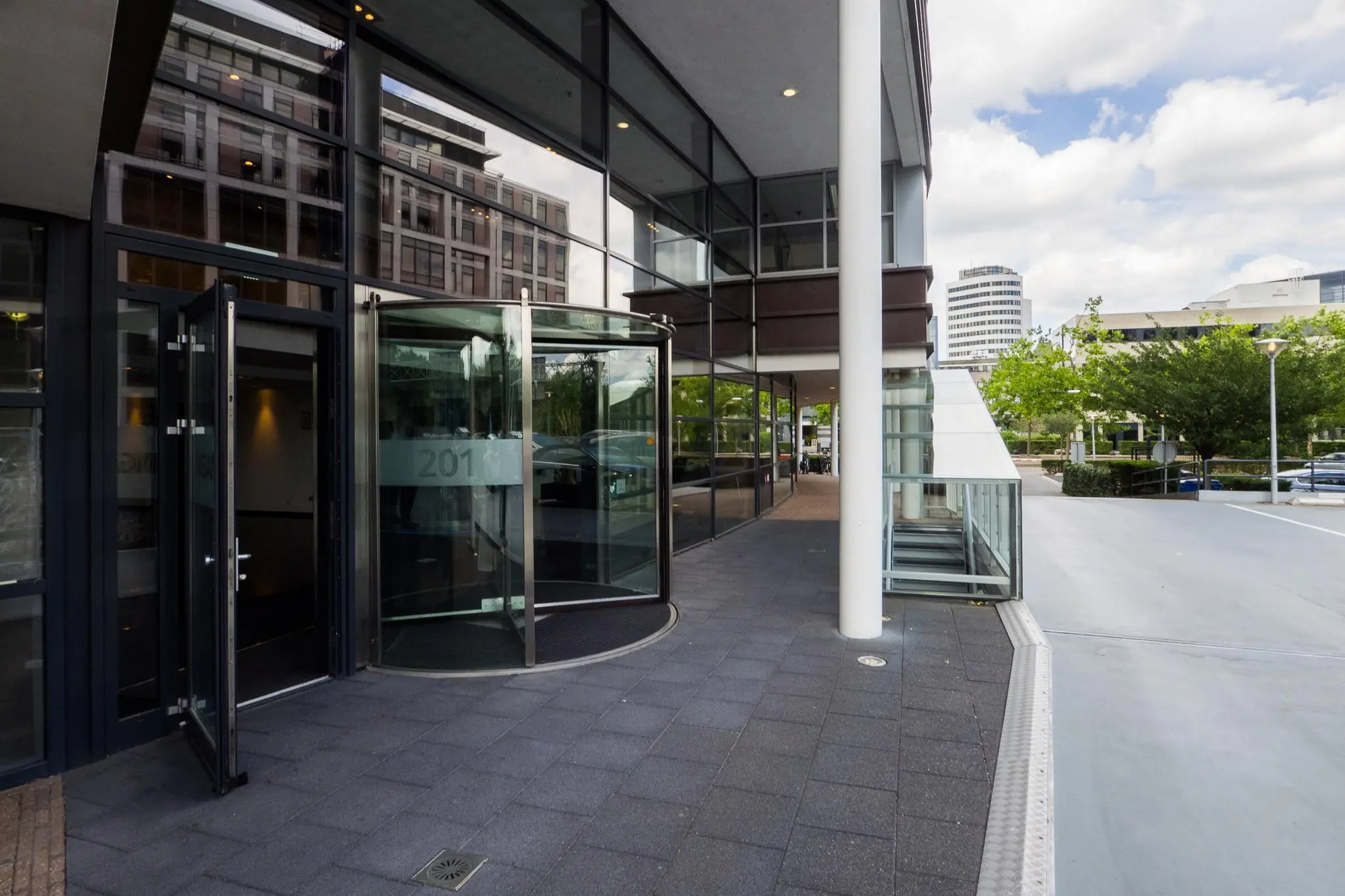 Ingang van een modern kantoorgebouw aan de Euclideslaan met een glazen draaideur en omliggende stadsbebouwing.
