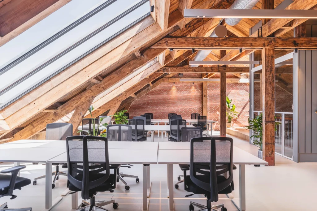 Modern ingerichte kantoorruimte met houten dakbalken en veel natuurlijk licht.