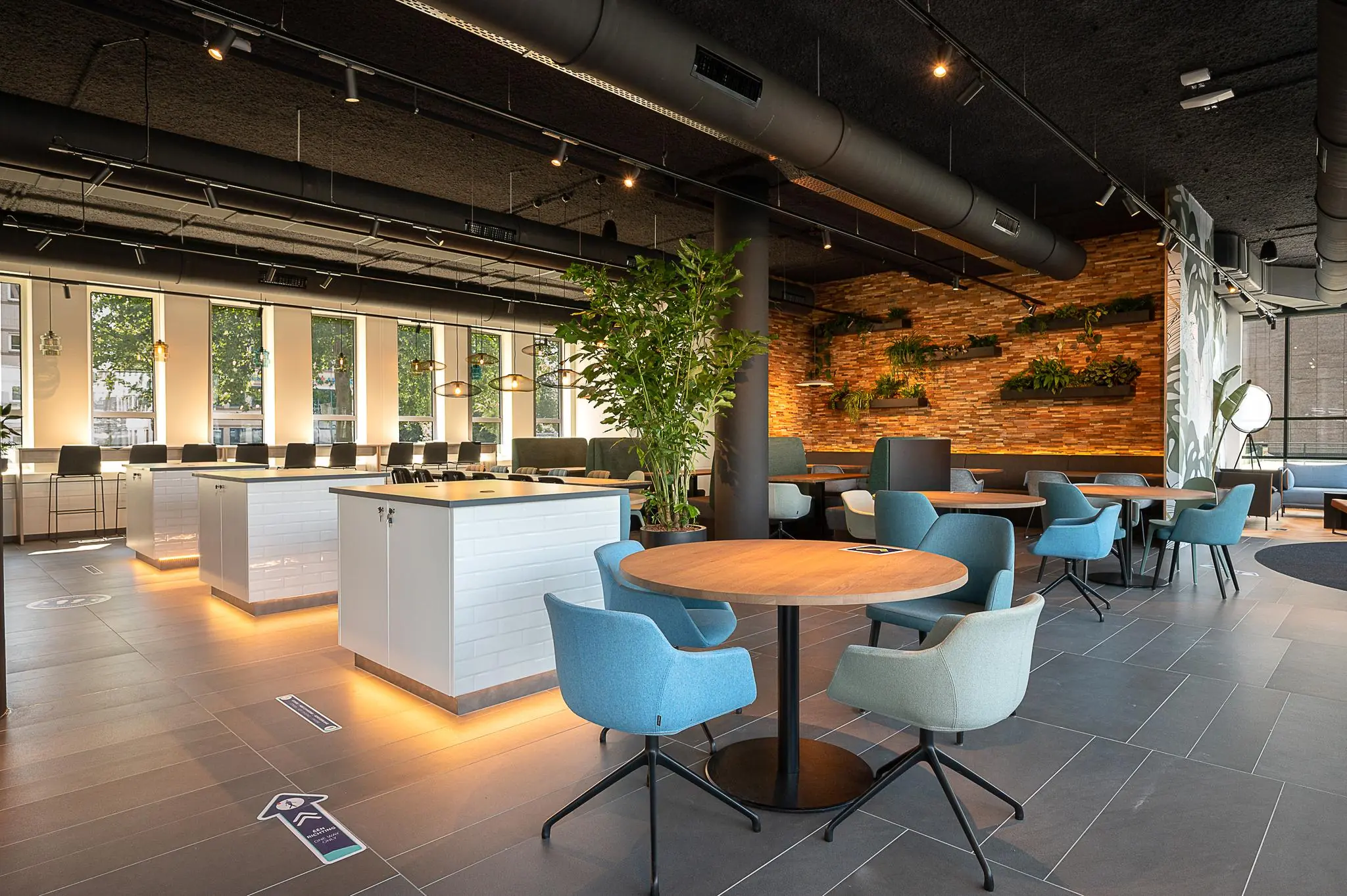 Moderne, sfeervol ingerichte kantoorruimte aan de Watermanweg met zitjes, veel daglicht en groene accenten.